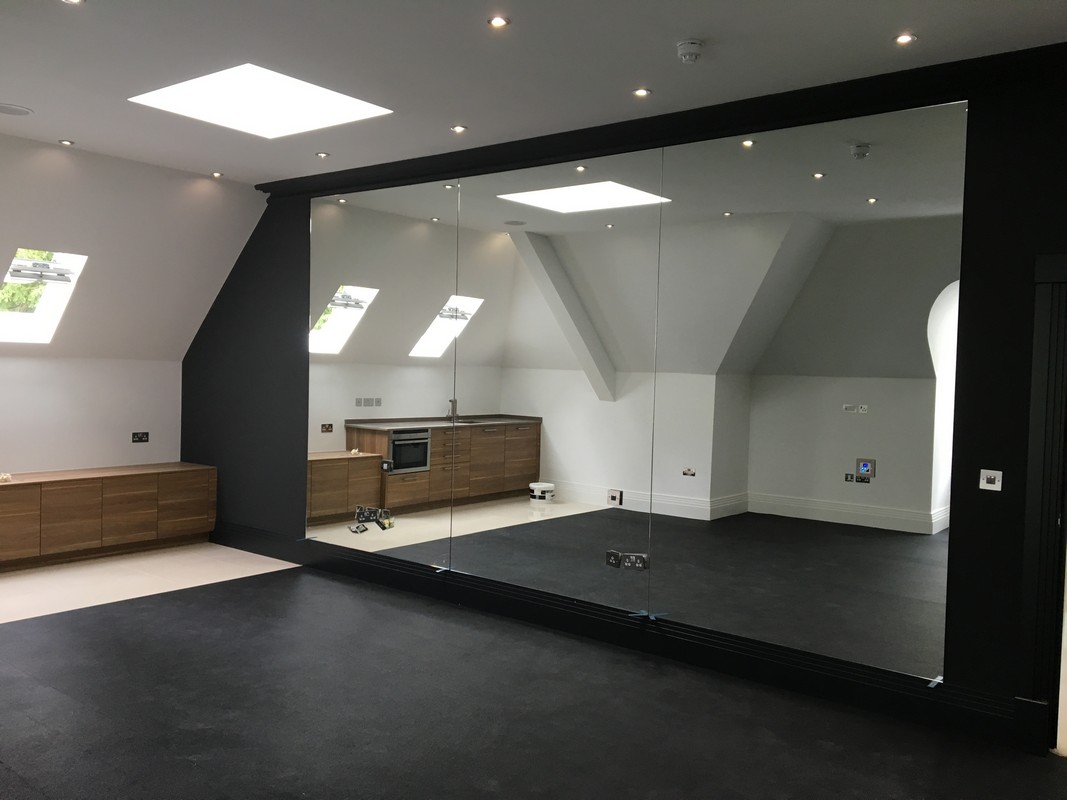 Frameless glass wall dividing loft conversion in Kilburn